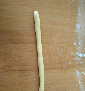 另取小块面团搓成细条，卷起来成一个圈圈。