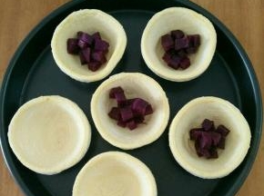 拿出蛋挞皮，放上适量紫薯粒。