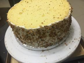 放入另一片蛋糕，边缘抹上奶油，然后撒入核桃碎