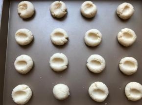 用拇指在面团中间按一个小坑