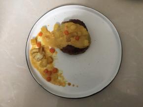 盘中放入煎好的牛肉饼，淋入咖喱汁