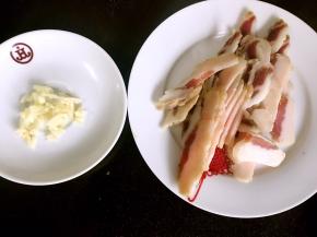 将蒜去皮洗净切末，腊肉洗净去皮切薄片