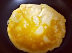 起油锅，油温7成时倒入打散的蛋液，小火煎鸡蛋饼。待蛋液凝固后用铲子将鸡蛋饼切小块，盛出备用。