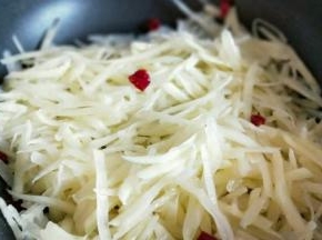 热油锅，加入切好的红辣椒和蒜炒香，加入土豆丝。