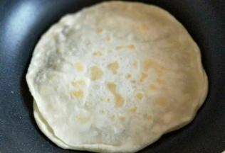 醒好的面团，搓长条。再切大小等份的小面团。揉圆。第一张饼，将平底锅中刷一层薄薄的玉米油，放入饼胚。待饼胚鼓起来，两面微黄即可。