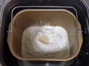除黄油以外的面包材料都放入面包机内（先液体后粉类的顺序），在面粉中间挖个洞，把酵母粉倒入，启动和面程序。