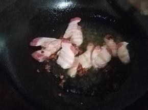 准备一口铁锅，无水加植物油热锅，五分热的时候加入花椒跟八角，猪五花。