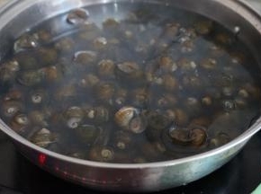 锅里的水烧开后，放入田螺，焯几分钟