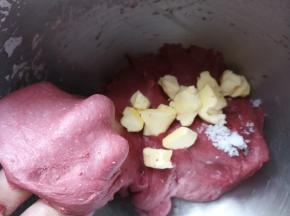 启动厨师机揉面，揉至面团光滑加入盐和黄油，继续启动厨师机揉面