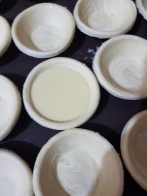 提前取出冷冻的挞皮，在烤盘内摆好，有时间最好缓冻一下。