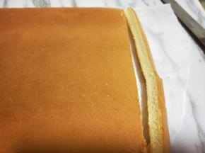 蛋糕烤好后，戴上隔热手套迅速取出烤盘，垂直摔一下，震出热气，趁热撕下油纸，翻面朝上，撕掉油纸后马上将蛋糕翻面，正面朝上，不然水蒸气加热气会导致蛋糕皮被粘掉。再将蛋糕四边切整齐。