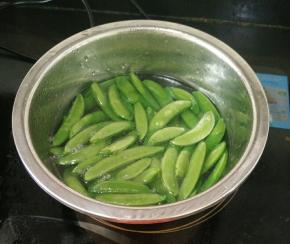 盆里放适量水，加入适量油和少许盐，烧开后放入荷兰豆焯水。荷兰豆变色即可捞出。