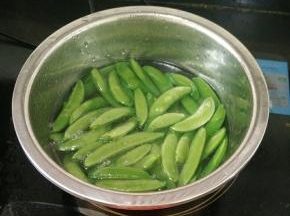 盆里放适量水，加入适量油和少许盐，烧开后放入荷兰豆焯水。荷兰豆变色即可捞出。