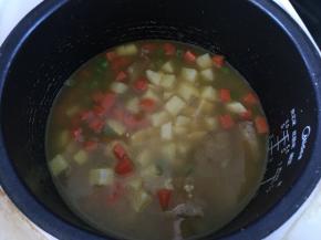 大米淘洗干净放入电饭锅中，倒入咖喱排骨和土豆，加入适量清水