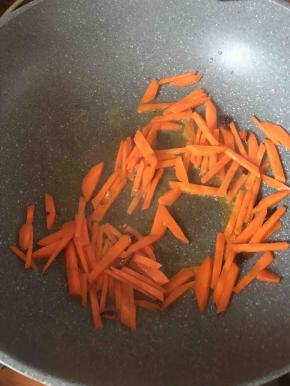 接着放入胡萝卜条翻炒约3分钟左右。