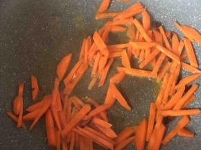 接着放入胡萝卜条翻炒约3分钟左右。