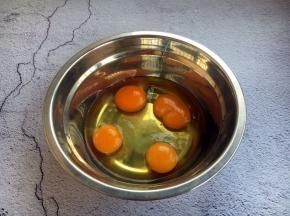 将鸡蛋磕入小盆中。