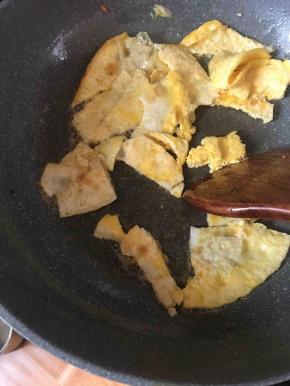 用锅铲把鸡蛋饼打碎了盛出备用。