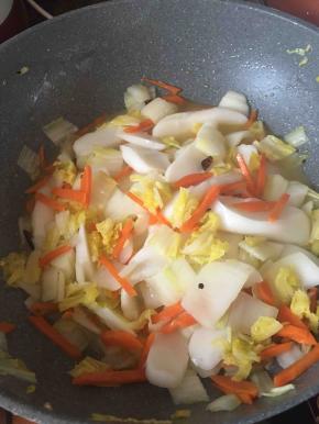 倒入切好的白粿片，再加入适量的开水一起炒。本来白粿粘连着，加了水就会散开了，更容易翻炒均匀。