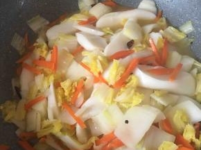 倒入切好的白粿片，再加入适量的开水一起炒。本来白粿粘连着，加了水就会散开了，更容易翻炒均匀。