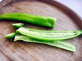 青椒切去根部，一破为二，摘去青椒籽。