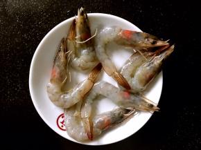 将基围虾剪掉虾须，剥去外皮，挑出虾线，留下虾头和虾尾