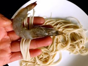 用面条将腌制好的基围虾缠绕裹严（虾尾和虾头留外面）