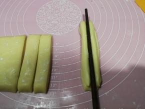 两根重叠，用一根筷子在中间压一道印痕，反过来也压一下，两手分别拉着两端将面条生坯抻长至约20cm长