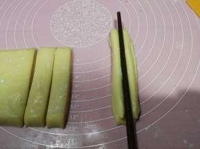 两根重叠，用一根筷子在中间压一道印痕，反过来也压一下，两手分别拉着两端将面条生坯抻长至约20cm长