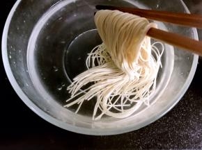 煮沸后，面条变软捞出，放入凉水中浸泡一会儿