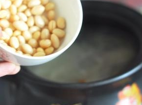 倒入提前泡好的黄豆，盖上砂锅盖继续煲煮一小时或两小时。