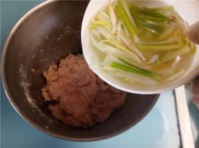 葱姜水分三次加入肉末中，每加一次都要充分搅拌均匀再添加。搅拌时要朝一个方向搅拌。
