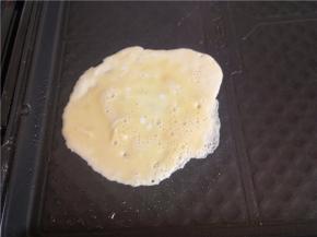 放一勺蛋液，慢慢摊开。