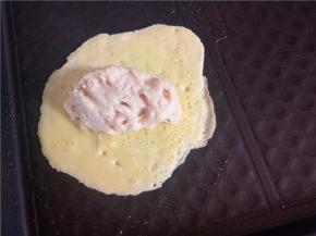 蛋皮煎到半熟时将肉馅放到蛋皮的一侧。