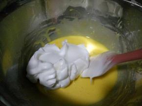 取1/3蛋白霜加入蛋黄糊中用刮刀用翻拌的手法翻拌均匀