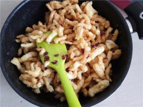 关火后立即将炸好的面条和蔓越莓倒入锅中，趁热快速翻拌，尽量让面条都能裹上糖浆。