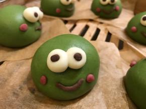 取适量可可粉面团揉成小细条，弯起放在菠菜面团上当嘴巴