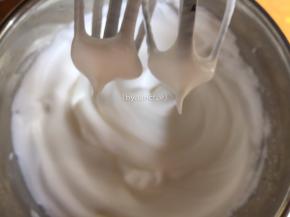 .打到较细泡泡时再加入剩下细砂糖的一半继续打发，打到棉花状细腻泡泡时加入剩下的细砂糖继续打发。打发至打蛋器提起冒直立小尖即可
