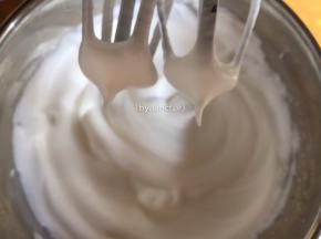 .打到较细泡泡时再加入剩下细砂糖的一半继续打发，打到棉花状细腻泡泡时加入剩下的细砂糖继续打发。打发至打蛋器提起冒直立小尖即可
