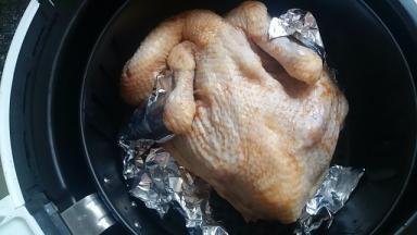 烤之前给我的烤鸡穿上锡纸，防止翅膀和腿烤糊，放进炸锅，表面刷上蜂蜜，选择烤鸡程序