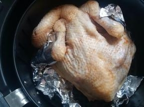 烤之前给我的烤鸡穿上锡纸，防止翅膀和腿烤糊，放进炸锅，表面刷上蜂蜜，选择烤鸡程序