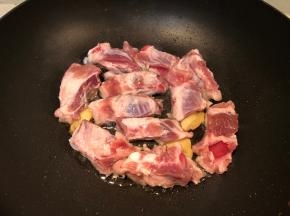 下入排骨煎至两面变色