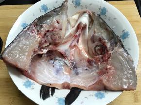 把鱼头一分为二，便于煎制，入味。