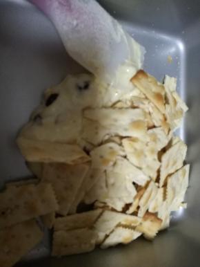 倒入不粘盘加入饼干，按压折叠拉扯