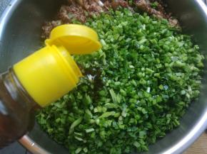 放入肉馅的一边。放入玉米油适量，把韭菜用油包裹住，这样做韭菜不会出汤。然后再和肉馅拌匀。