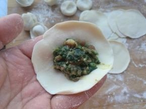 拿一个饺子片，放在左手手指上，放入适量的馅。