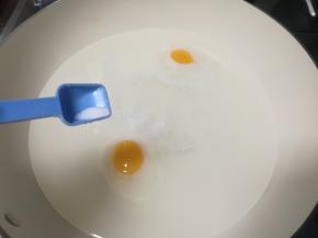 转最小火，磕入鸡蛋，加入一点点盐。