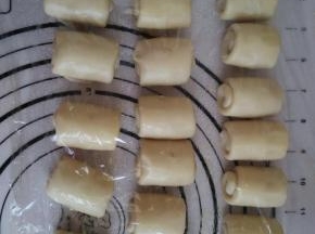 再一次擀成牛舌状，自上而下卷起盖保鲜膜松弛15分钟