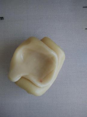 取松弛好的面卷在中间用拇指按个坑