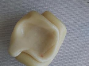 取松弛好的面卷在中间用拇指按个坑